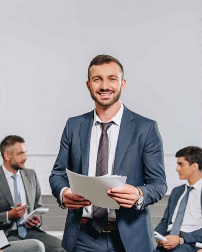 happy-business-coach-standing-in-front-of-business-LASE3PY-1024x683-1.jpg